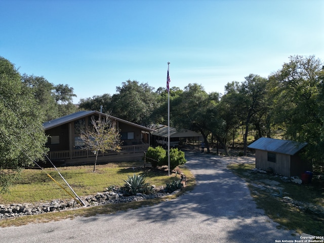 view of front facade featuring a front lawn and a shed