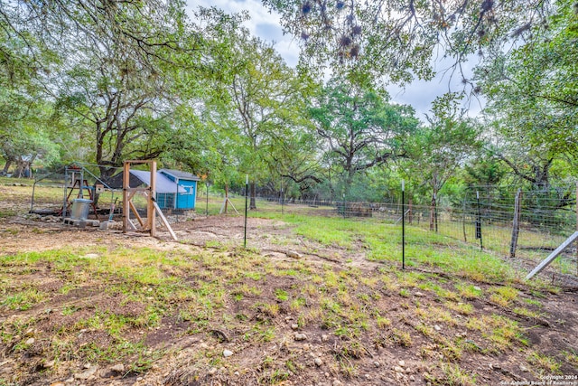 view of yard featuring a playground and a storage unit