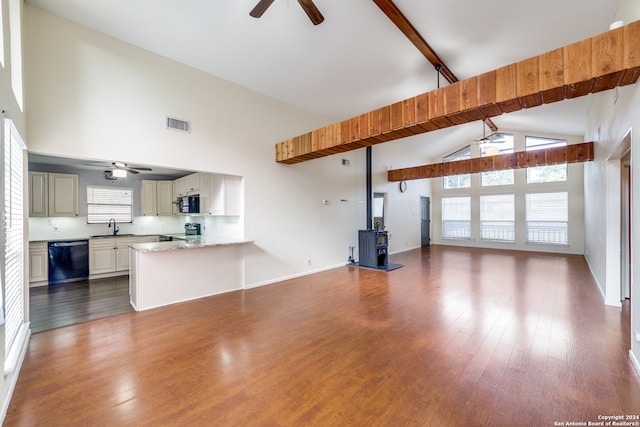 unfurnished living room with dark hardwood / wood-style floors, beam ceiling, sink, and high vaulted ceiling