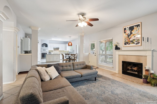 living room featuring light tile patterned flooring, ceiling fan, and a tiled fireplace