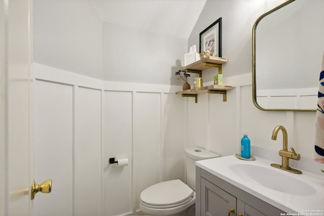 bathroom featuring vanity, toilet, and lofted ceiling