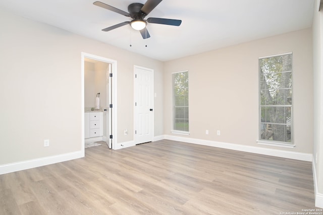 unfurnished bedroom with light hardwood / wood-style floors, ceiling fan, and connected bathroom