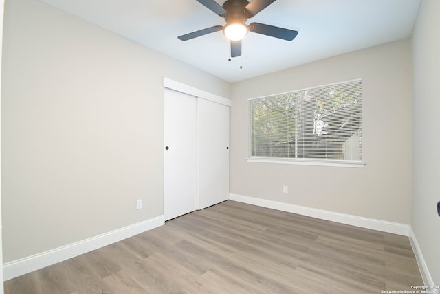 unfurnished bedroom featuring wood-type flooring, ceiling fan, and a closet