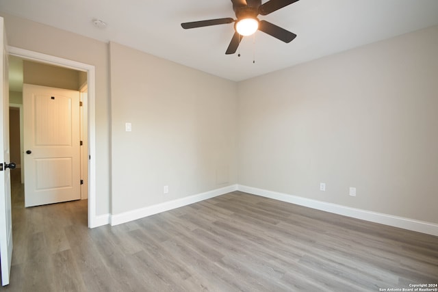 empty room with ceiling fan and light hardwood / wood-style flooring