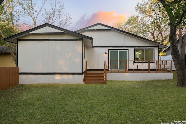 back house at dusk with a lawn