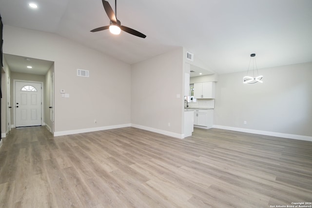 unfurnished living room featuring light wood-type flooring, ceiling fan, and vaulted ceiling