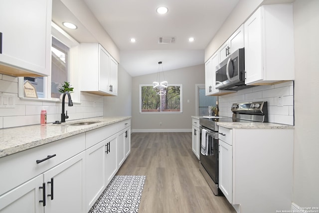 kitchen with white cabinetry, lofted ceiling, sink, and stainless steel appliances