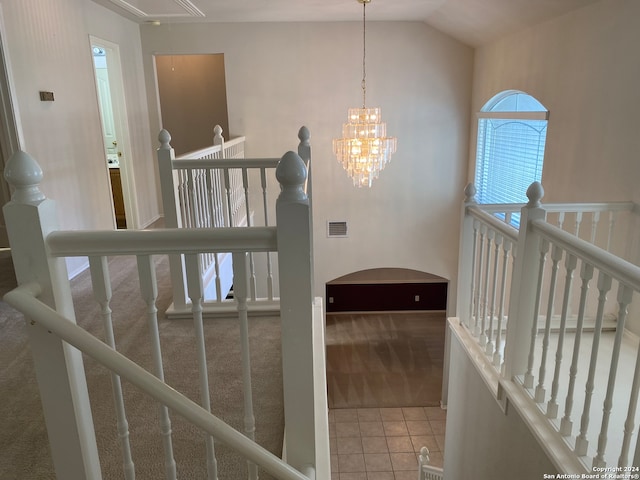 staircase featuring carpet flooring, an inviting chandelier, and lofted ceiling