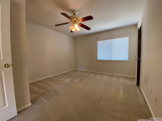 empty room with ceiling fan and light carpet