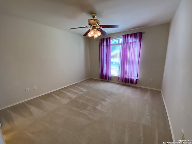 spare room with light colored carpet and ceiling fan