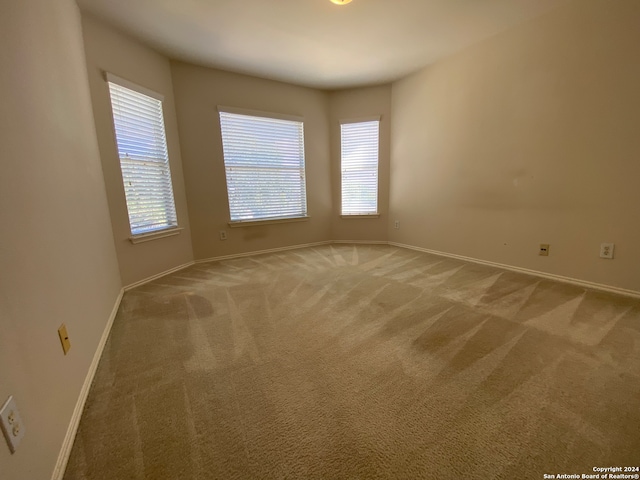 carpeted spare room featuring plenty of natural light