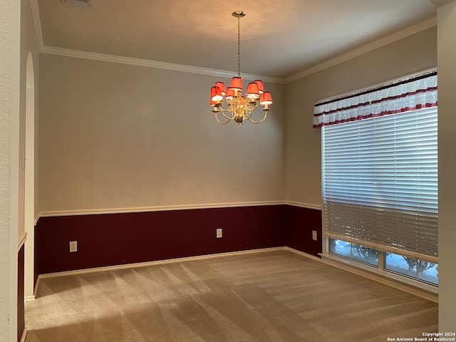 unfurnished room with crown molding, an inviting chandelier, and carpet floors