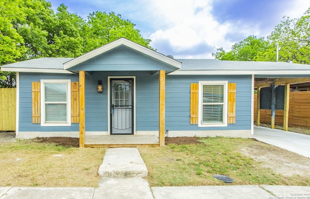 view of front of home with a porch, a carport, and a front yard