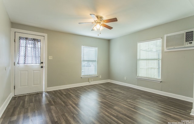 entrance foyer featuring dark wood-type flooring, an AC wall unit, and ceiling fan