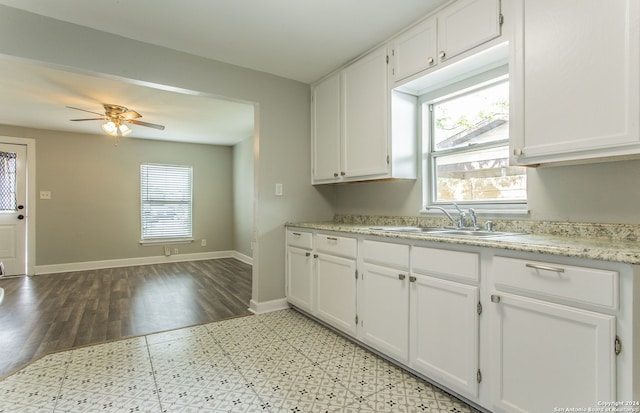 kitchen featuring ceiling fan, white cabinetry, sink, and light hardwood / wood-style flooring