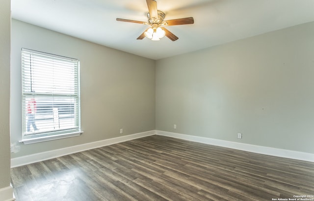 spare room with plenty of natural light, dark wood-type flooring, and ceiling fan