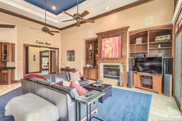 living room featuring crown molding, a towering ceiling, a premium fireplace, and light tile patterned floors