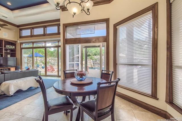 tiled dining room featuring a towering ceiling and ceiling fan with notable chandelier