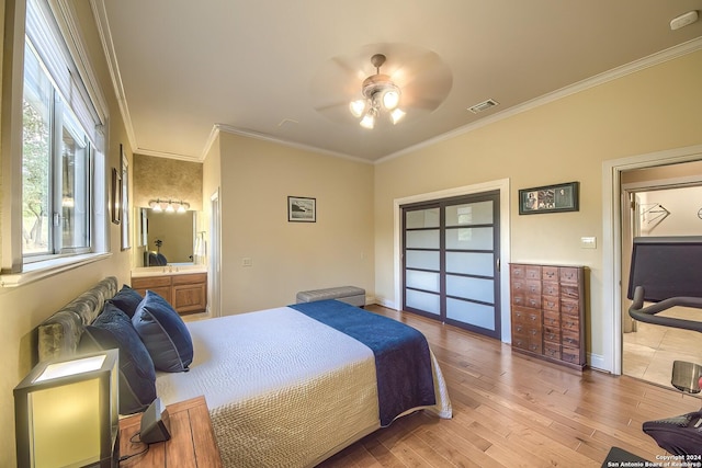 bedroom featuring ceiling fan, ornamental molding, ensuite bath, and light wood-type flooring