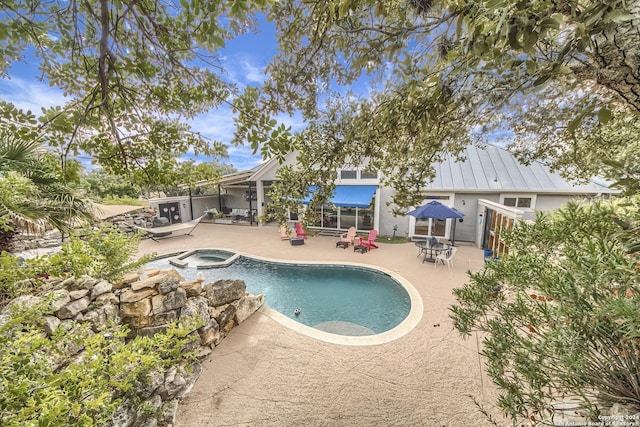 view of pool with an in ground hot tub and a patio