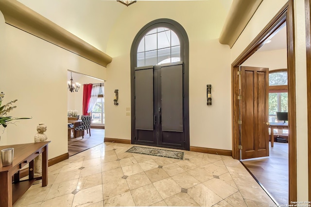 foyer featuring a notable chandelier and a towering ceiling