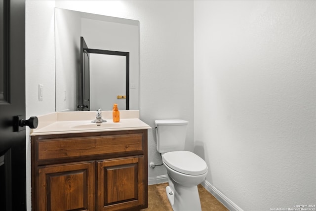 bathroom featuring tile patterned flooring, vanity, and toilet