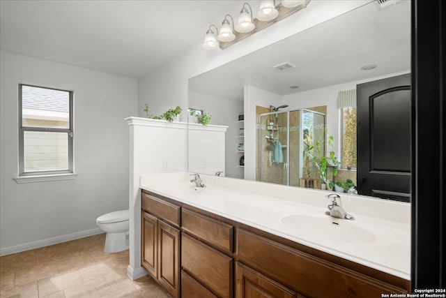 bathroom with tile patterned flooring, vanity, toilet, and an enclosed shower