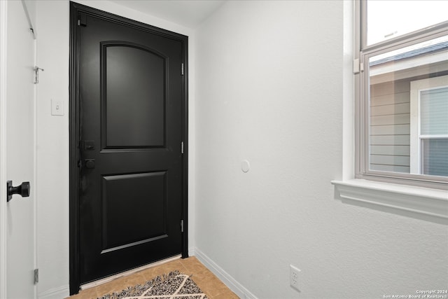 doorway to outside with light tile patterned floors