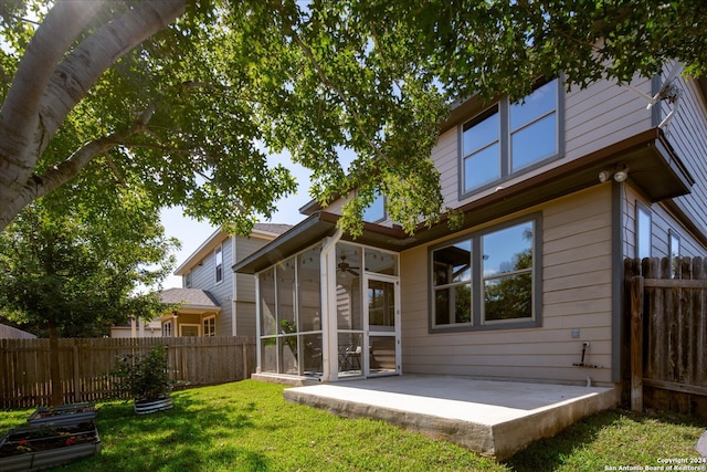 rear view of property with a patio area, a sunroom, and a yard