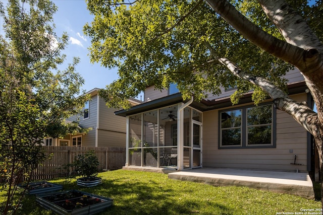 rear view of house with a sunroom and a lawn