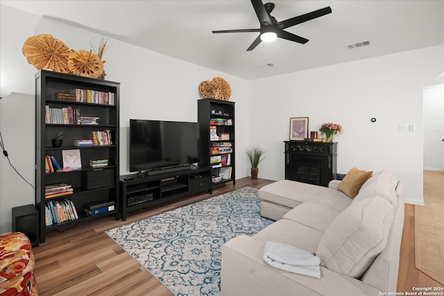 living room featuring hardwood / wood-style floors and ceiling fan