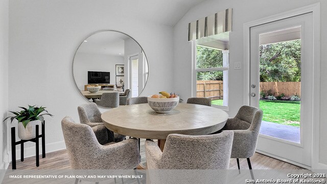 dining room with light wood-type flooring and lofted ceiling