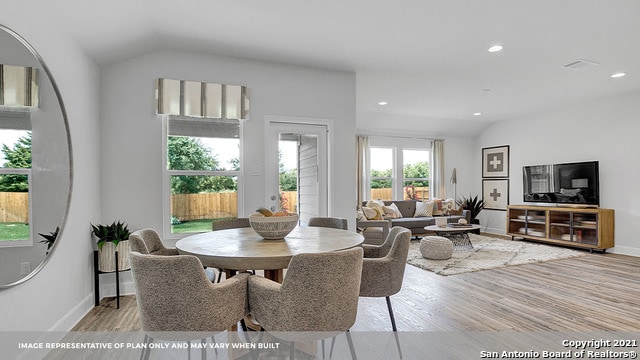 dining space with light hardwood / wood-style floors and lofted ceiling