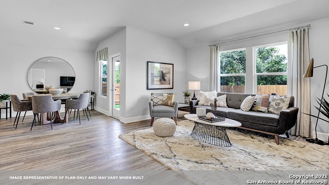 living room with light wood-type flooring and lofted ceiling