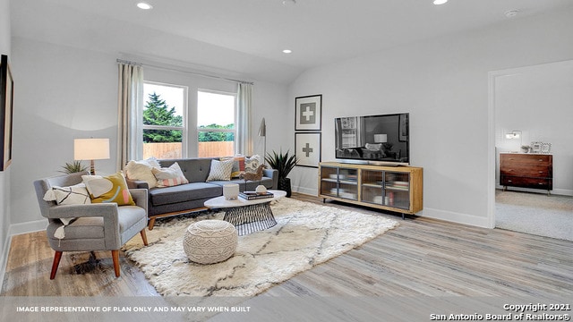 living room with lofted ceiling and light hardwood / wood-style flooring