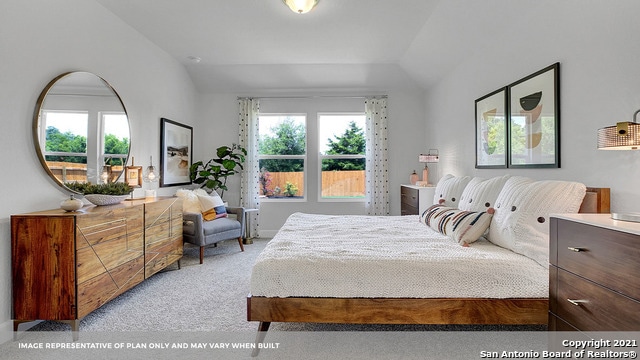 bedroom with lofted ceiling and light colored carpet