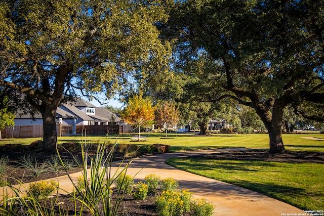 view of community with fence and a lawn