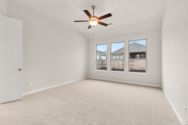 empty room featuring light carpet, ceiling fan, visible vents, and baseboards