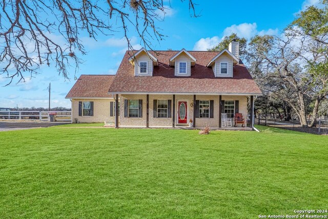 new england style home with a front yard and a porch