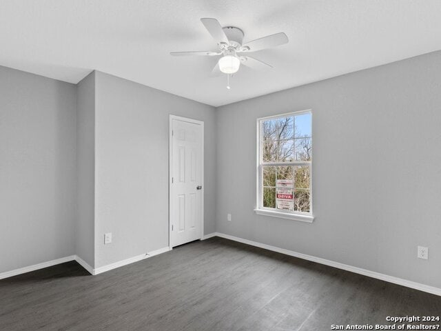 spare room featuring dark wood-type flooring and ceiling fan