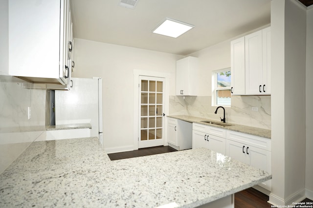 kitchen with dark wood-type flooring, white cabinetry, sink, and light stone countertops