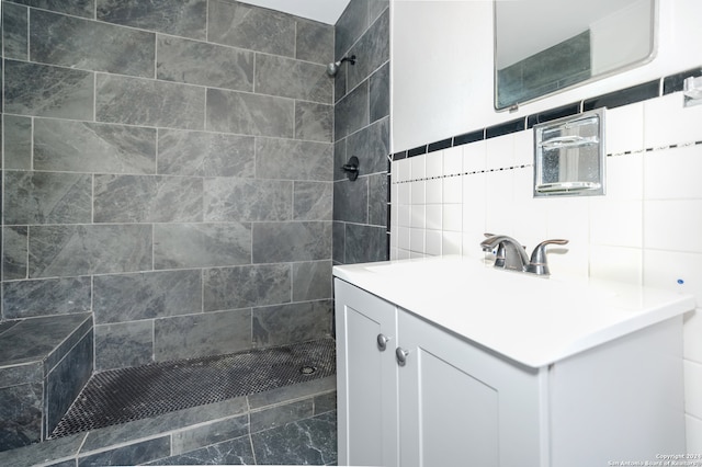 bathroom featuring vanity, a tile shower, and tile walls