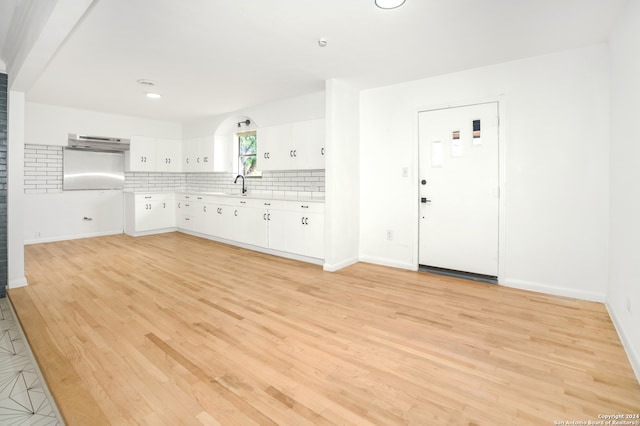 kitchen featuring sink, tasteful backsplash, ventilation hood, white cabinetry, and light wood-type flooring