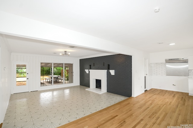 unfurnished living room with crown molding and light hardwood / wood-style flooring