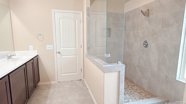 bathroom featuring tiled shower and vanity