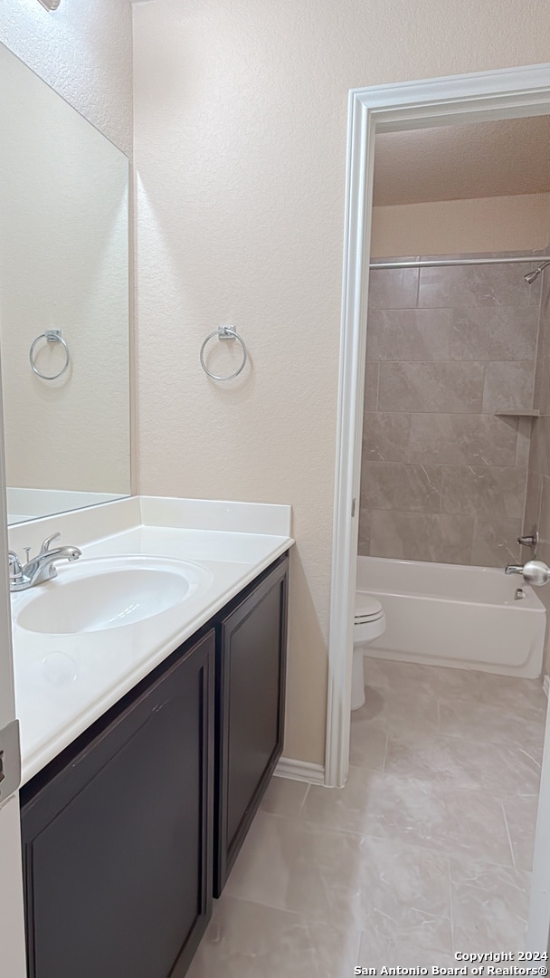 full bathroom with vanity, toilet, and tiled shower / bath combo