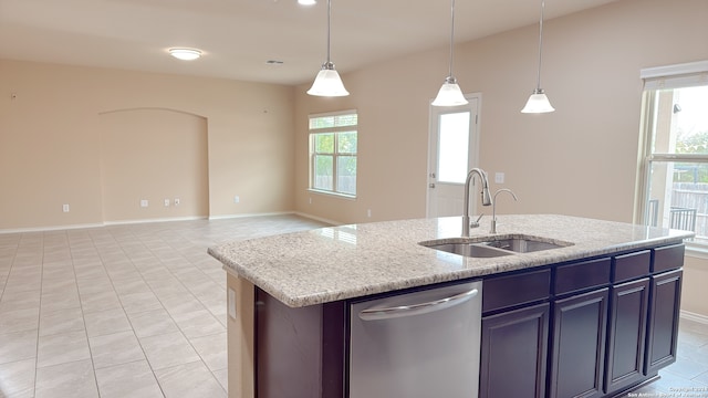 kitchen featuring dishwasher, hanging light fixtures, sink, and an island with sink