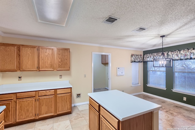 kitchen with ornamental molding, decorative light fixtures, a notable chandelier, a textured ceiling, and a center island