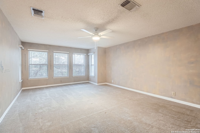 carpeted spare room with a textured ceiling and ceiling fan