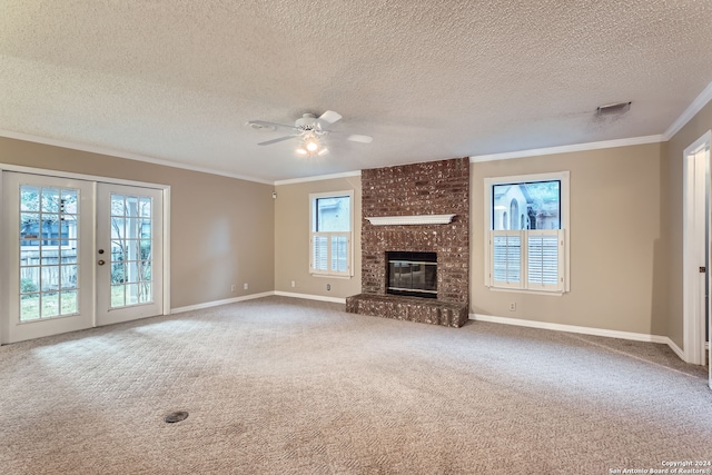 unfurnished living room featuring a brick fireplace, a textured ceiling, ceiling fan, and carpet floors